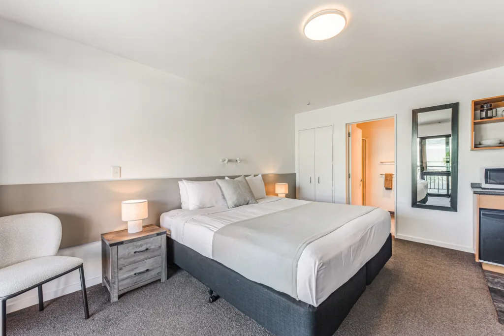Courtyard Studio with king bed, lounge chair, wardrobe and ensuite