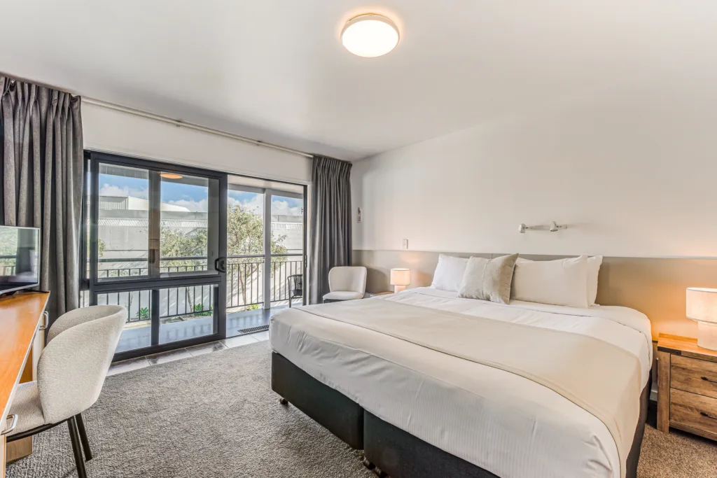 Courtyard Studio with king bed and sliding doors opening to the upper walkway and courtyard view