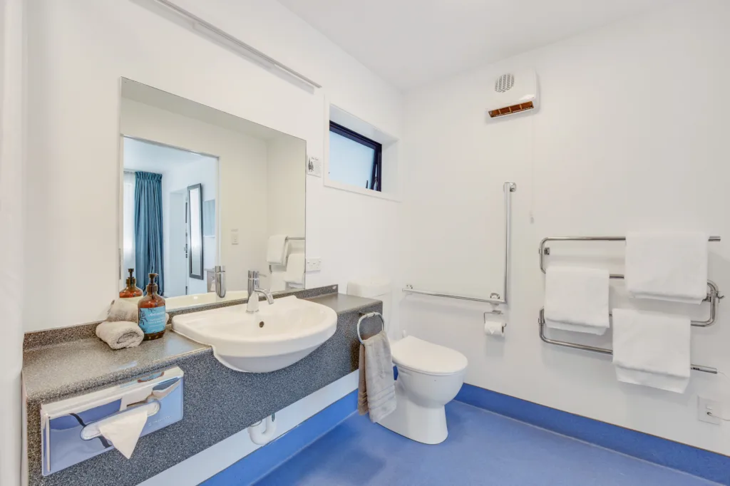 Courtyard Suite accessible bathroom with vanity, grab rails, heated towel rail and Antipodes toiletries