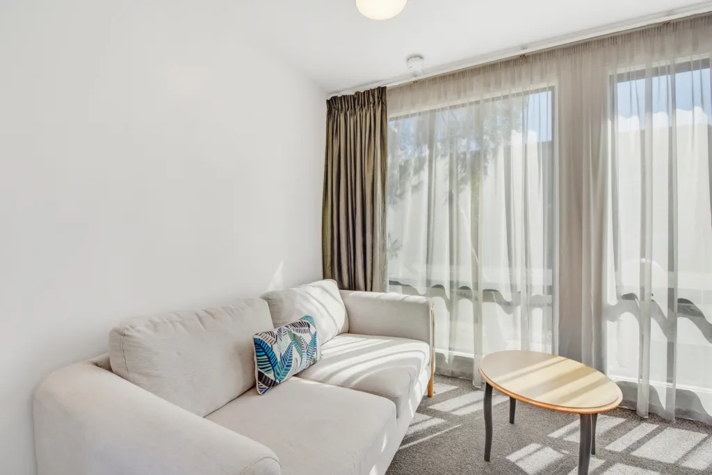 Sunlit Courtyard Suite lounge with grey sofa and coffee table