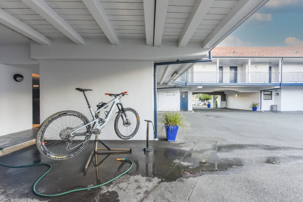 Covered bike wash with work stand, hose and pump beside the courtyard