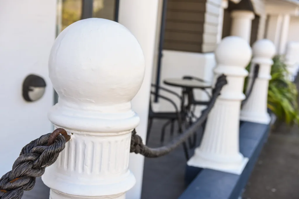 White rope bollard in front of a ground-floor patio