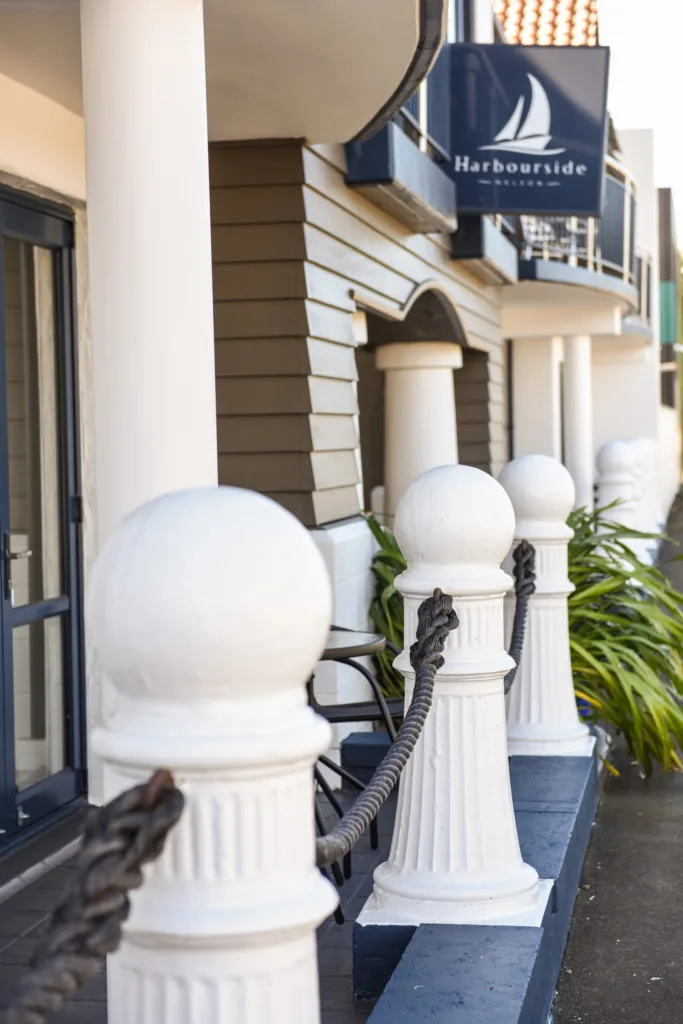 Harbourside Nelson sign above white rope bollards and ground-floor patios